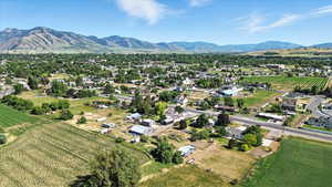 Aerial view of property and surrounding area featuring mountains, rows of crops, and rural landscape
