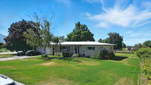 View of front of home featuring driveway, a front lawn, and brick siding
