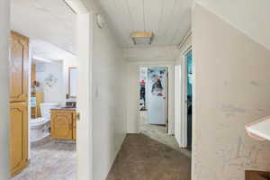 Hall with a sink and light carpet