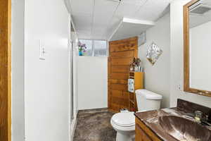 Full bathroom featuring a stall shower, vanity, and a paneled ceiling