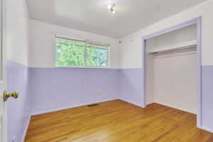Unfurnished bedroom with light wood-style floors and a closet