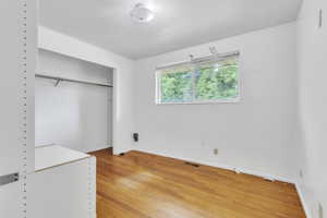 Unfurnished bedroom featuring light wood-style floors and a closet