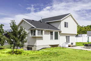 Rear view of house with a patio area and roof with shingles
