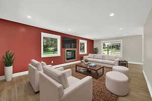 Living area featuring light wood finished floors, recessed lighting, and a glass covered fireplace