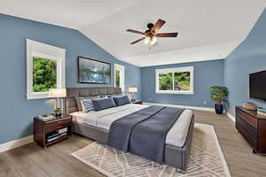 Bedroom with light wood-style floors, vaulted ceiling, and ceiling fan