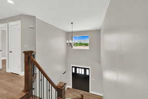 Entryway featuring light wood-type flooring and a chandelier