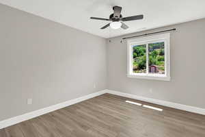 Empty room with ceiling fan and wood finished floors