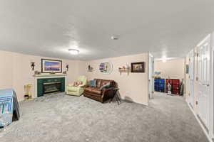 Carpeted living room featuring a textured ceiling and a high end fireplace