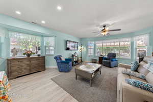 Living area featuring a ceiling fan, light wood-style flooring, and recessed lighting