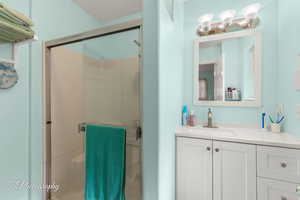Bathroom featuring a shower stall and vanity