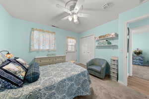 Bedroom with light carpet, a closet, and a ceiling fan