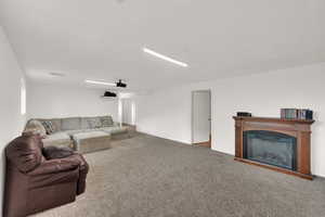 Living room with carpet floors and a glass covered fireplace