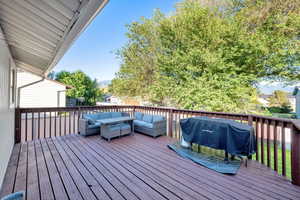 Wooden deck with outdoor lounge area, area for grilling, and a mountain view