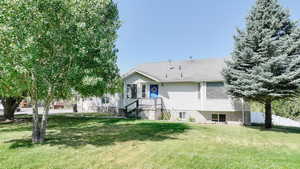 Back of property with a lawn
