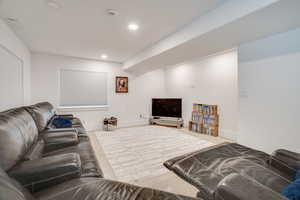 Carpeted living area with recessed lighting and baseboards