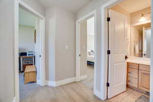 Corridor featuring light wood-style flooring and baseboards