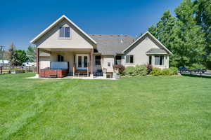 Rear view of property featuring a hot tub, french doors, stucco siding, and a patio
