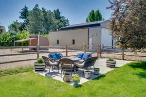 View of patio / terrace featuring a pole building, an outbuilding, a detached garage, and an outdoor hangout area