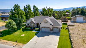 View of front facade featuring concrete driveway, brick siding, roof with shingles, and a mountain view