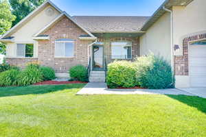 View of front of property with brick siding and a front lawn