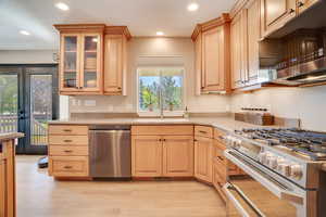 Kitchen with appliances with stainless steel finishes, light brown cabinets, light countertops, and recessed lighting