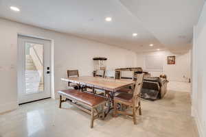 Dining area featuring finished concrete floors, recessed lighting, and stairs