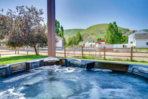 View of patio / terrace with a hot tub and a mountain view