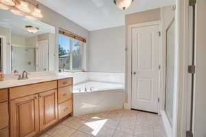 Bathroom with vanity, a shower stall, a bath, and tile patterned floors