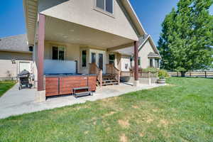 Back of property with a hot tub, a patio area, stucco siding, and french doors