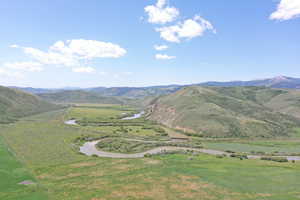 View of mountain background featuring a nearby body of water and rural landscape