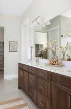 Bathroom featuring double vanity, tile patterned flooring, tiled shower, and a closet