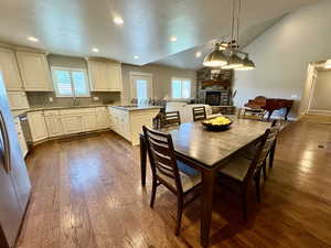 Dining room with a fireplace, lofted ceiling, dark wood-style floors, and recessed lighting