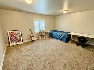 Bedroom featuring carpet floors and baseboards