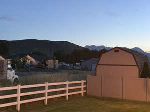 View of yard with a barn, an outdoor structure, and a mountain view