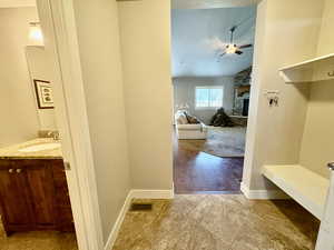 Mudroom featuring a ceiling fan, a fireplace, lofted ceiling, and light tile patterned floors