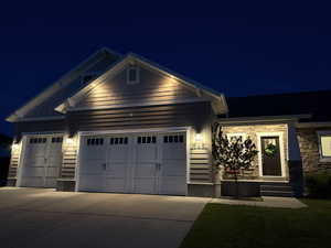 View of front facade featuring a garage, concrete driveway