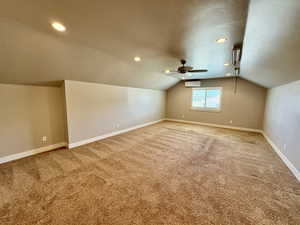 Bonus room featuring lofted ceiling, carpet flooring, ceiling fan, an AC wall unit, and recessed lighting