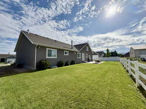 Rear view of house with a patio area, stucco siding, and roof with shingles