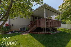 Rear view of property featuring a wooden deck, stairway, and stucco siding