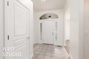 Foyer entrance featuring light tile patterned floors and baseboards