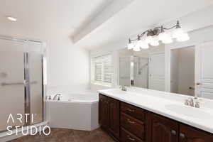 Primary full bathroom with a stall shower, a bath, double vanity, dark tile patterned floors, and recessed lighting