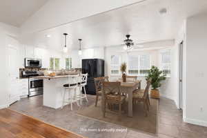 Virtually Staged - Dining area with light tile patterned floors, lofted ceiling, a ceiling fan, and recessed lighting