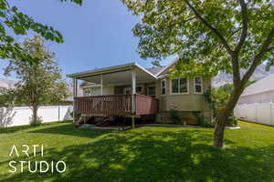 View of back of home with a fenced backyard, a covered deck, and stucco siding