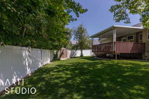 Fenced backyard with a shed and a deck