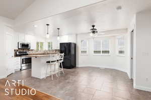 Kitchen with a kitchen bar, a center island, decorative light fixtures, white cabinetry, and recessed lighting