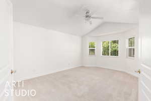 Primary Bedroom with light colored carpet, lofted ceiling, and ceiling fan