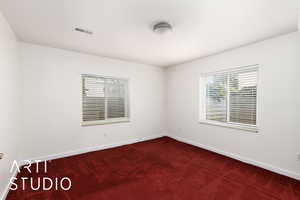 Bedroom featuring dark carpet and baseboards