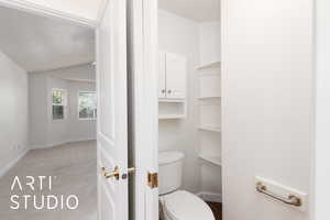 Primary bathroom with a textured ceiling and vaulted ceiling