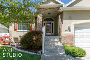View of exterior entry with stucco siding and an attached garage
