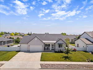 Ranch-style home featuring board and batten siding, a garage, a residential view, driveway, and a gate
